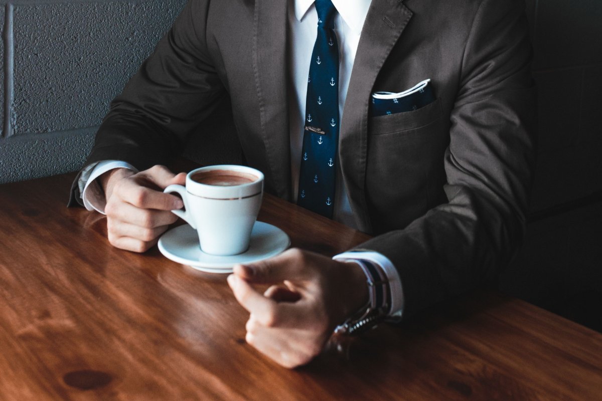 Man with suit sipping coffee